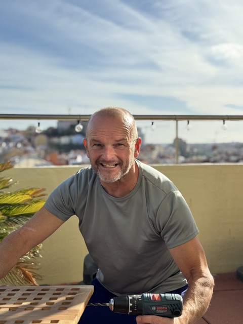 Marco Blom with a drill, on a terrace overlooking Lisbon
